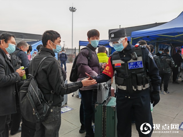 民警在出站口查看旅客健康码